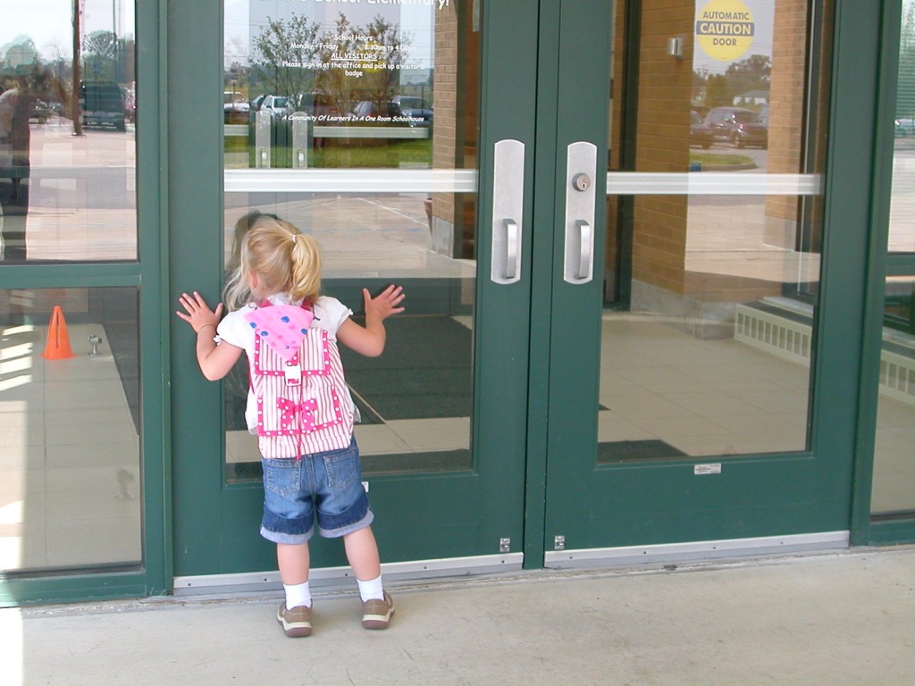 3 year old Maddie looks in to her early childhood class on her first day of school.